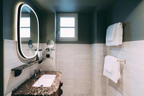 a bathroom with a sink and a mirror at 1.75 Paris La Trêve in Paris