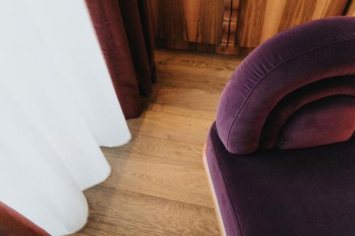 a purple couch sitting on top of a wooden floor at 1.75 Paris La Trêve in Paris