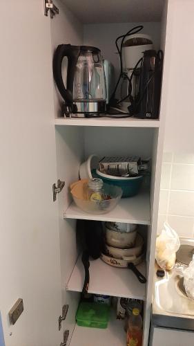a kitchen cabinet filled with dishes and a tea kettle at Apartmán Almberg - Mitterdorf - Mitterfirmiansrout in Philippsreut