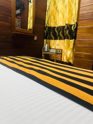 a bedroom with a black and yellow stripe carpet at MUM Jungle Inn in Ella