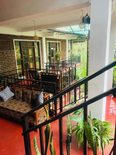 a porch with chairs and a couch on a balcony at MUM Jungle Inn in Ella