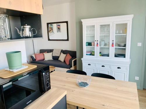 Il comprend une cuisine et un salon avec un canapé et un four micro-ondes. dans l'établissement Le Treich Laplene - Parking Wifi, à La Rochelle