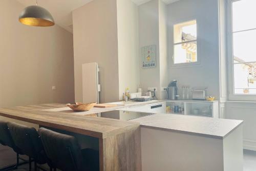 une cuisine avec un comptoir et des chaises. dans l'établissement Le Leonard - Beau T4 Refait a Neuf Hypercentre LR, à La Rochelle
