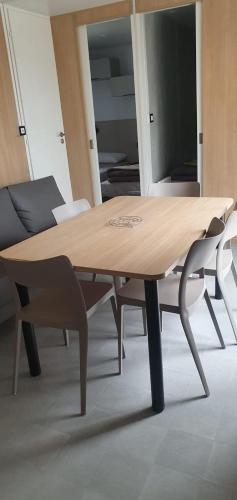 a wooden table and chairs in a room at Camping 4 étoiles à Sète in Sète