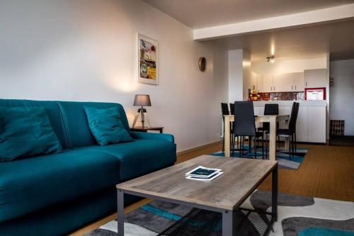 un salon avec un canapé bleu et une table dans l'établissement Le Grand Lazaret Vue Mer - Wifi, à La Rochelle