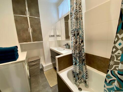une salle de bain avec une baignoire et un lavabo dans l'établissement Appartement Vaugirard - proche Tour Eiffel, à Paris