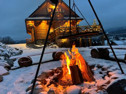 a fire pit in front of a log cabin at Chata Trzy Wierchy in Wisła
