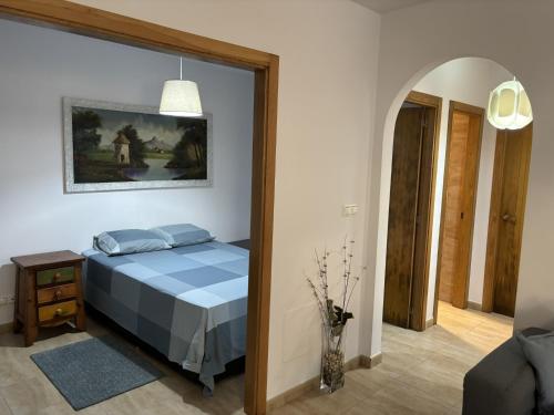 ein Schlafzimmer mit einem Bett mit einem Bild an der Wand in der Unterkunft Grupo Gontad Apartamento Travesía da Agra in A Coruña