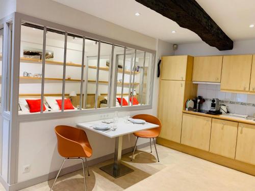 une cuisine avec une table blanche et deux chaises dans l'établissement Le Petit Cloutiers - Plein Centre Ville - Wifi, à La Rochelle