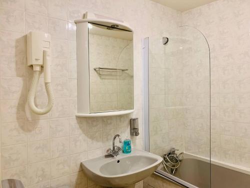 une salle de bain blanche avec un lavabo et une douche dans l'établissement Le Petit Cloutiers - Plein Centre Ville - Wifi, à La Rochelle