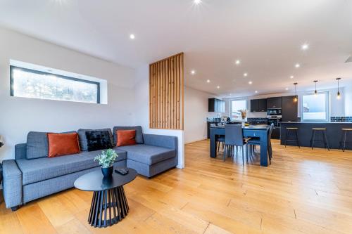 un salon et une cuisine avec un canapé et une table dans l'établissement Le Cocon - 3 lits - Billard - Parking gratuit - Terrasse - Wifi, à Wasquehal