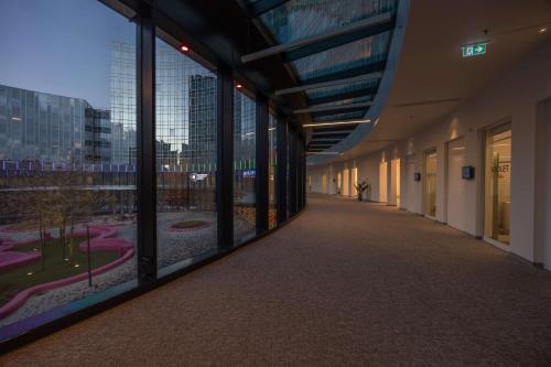 an empty hallway in a building with large windows at Park Inn by Radisson Amsterdam City West in Amsterdam