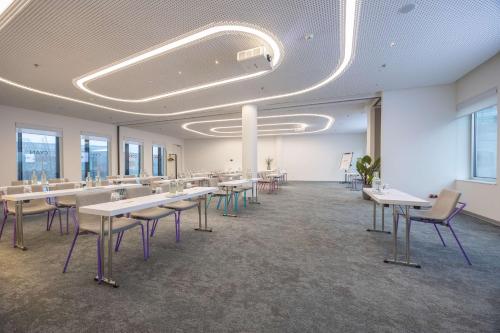 a large room with tables and chairs and windows at Park Inn by Radisson Amsterdam City West in Amsterdam