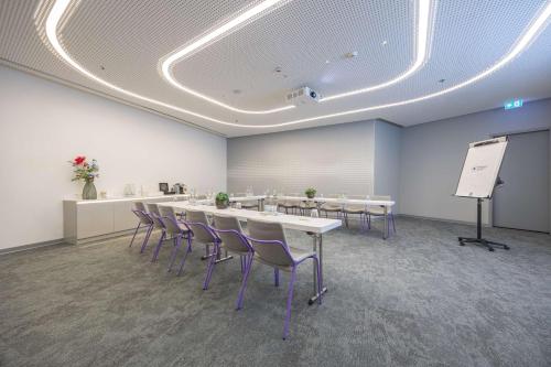 a conference room with tables and chairs and a whiteboard at Park Inn by Radisson Amsterdam City West in Amsterdam