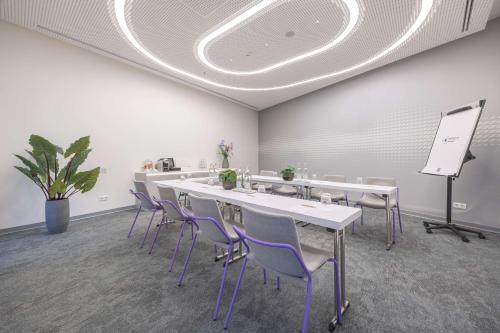 a conference room with white tables and purple chairs at Park Inn by Radisson Amsterdam City West in Amsterdam