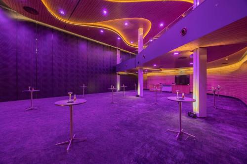 a purple room with tables in a room with purple lighting at Park Inn by Radisson Amsterdam City West in Amsterdam