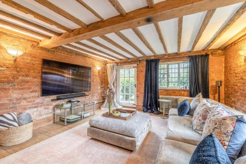 a living room with a couch and a tv at Cosy 5 Bed Cottage Retreat, Perfect for Families in Buckinghamshire