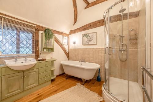 a bathroom with a tub and a sink and a shower at Cosy 5 Bed Cottage Retreat, Perfect for Families in Buckinghamshire