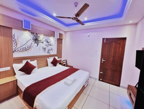 a bedroom with a bed and a ceiling fan at IvyArk Residency in Pinangode