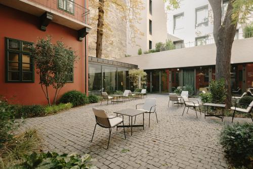 a patio with tables and chairs in front of a building at BoHo Hotel Budapest - Small Luxury Hotels in Budapest