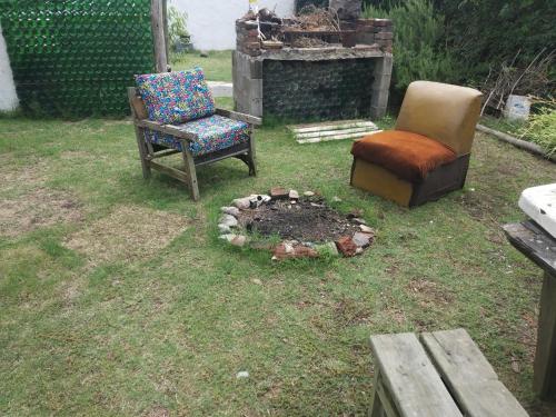dos sillas y una hoguera en un patio en Siempre bien, en Balneario Buenos Aires