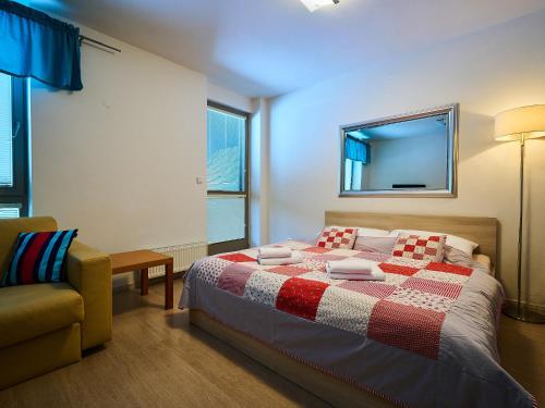 a bedroom with a bed and a chair and a mirror at Studio Harrachov by Interhome in Harrachov