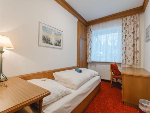 a room with a bed and a desk and a window at Holiday Home Riki by Interhome in Bruck an der Großglocknerstraße