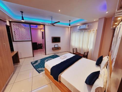 a bedroom with a large bed and a tv at IvyArk Residency in Pinangode