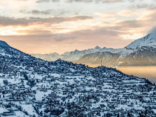 a city covered in snow with mountains in the background at Apartment Derborence 28 by Interhome in Nendaz