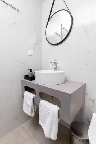 a bathroom with a sink and a mirror at Anele Luxury Suites - Roof Top Jacuzzi in Chania Town