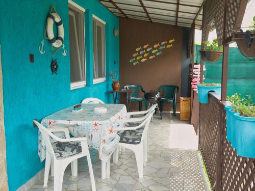 a table and chairs on a patio with a blue wall at Apartment Gagarin 2 by Interhome in Balatonkeresztúr