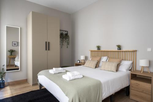 a bedroom with a large bed with two towels on it at Espaciosa Casa con 3 Dormitorios en Santander in Santander