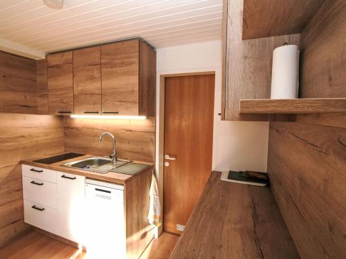 a small kitchen with wooden cabinets and a sink at Apartment Hannelore by Interhome in Omes