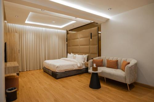 a bedroom with a bed and a couch at XYZ Hotel Al Yasmin in Riyadh