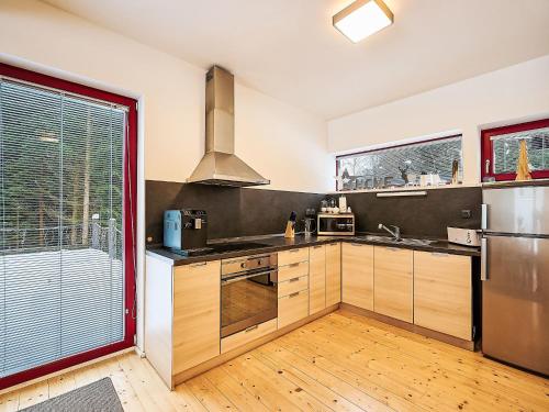 Una cocina con gabinetes de madera y electrodomésticos de acero inoxidable. en Chalet Harrachov by Interhome, en Harrachov