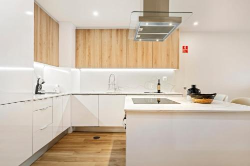 a kitchen with white cabinets and a sink at Sunset Vista 604 in Funchal