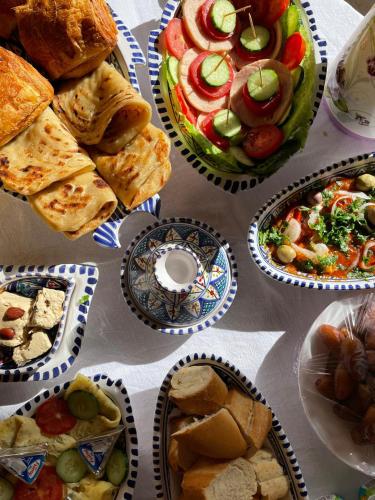 a table topped with plates of food and sandwiches at Appartement Chebbi in Tozeur
