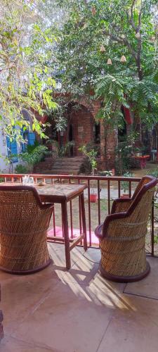 a picnic table and two chairs next to a fence at the secret garden in Pushkar