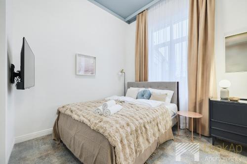 a bedroom with a bed and a large window at Kolorova Apart by LookAp - darmowy parking w centrum Łodzi! in Łódź