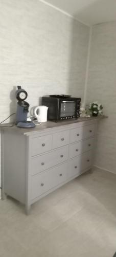 - une commode blanche avec un four micro-ondes dans l'établissement Appartement 1, à Saint-Germain-Laprade
