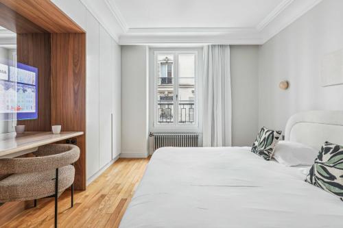 une chambre blanche avec un lit et un bureau dans l'établissement Magnificent Flat - 2BR-6P - Champs Elysées, à Paris
