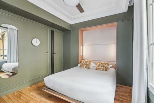 une chambre avec un lit blanc et un miroir dans l'établissement Magnificent Flat - 2BR-6P - Champs Elysées, à Paris