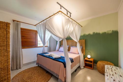 a bedroom with a canopy bed in a room at Bahia Soul - Morada Garú - Taipu de Fora - Península de Maraú in Taipu