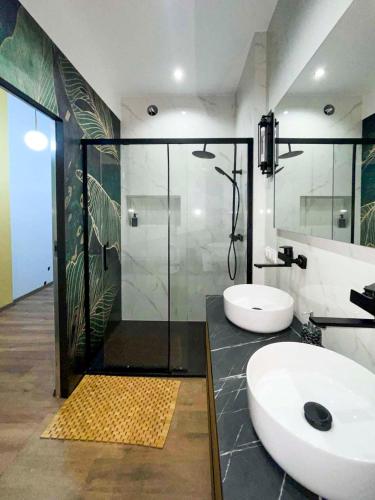 a bathroom with two sinks and a shower at Sami Swoi Kutno in Kutno