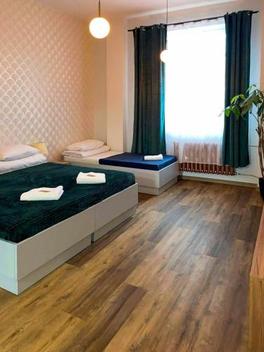 a bedroom with two beds and a large window at Sami Swoi Kutno in Kutno