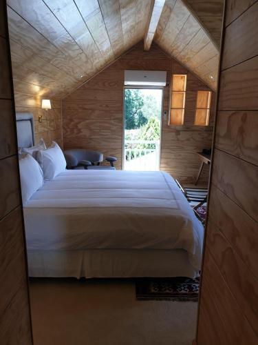 a bedroom with a large bed in a wooden room at Le Manoir Boutique Estate in Johannesburg