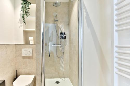 een douchecabine in een badkamer met een toilet bij Marais Elegence Suites - Two bedrooms in Parijs