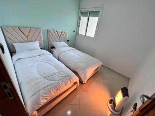 Dos camas una al lado de la otra en una habitación. en Charming Two Bedroom Apartment in Fes Near City Center, en Fez