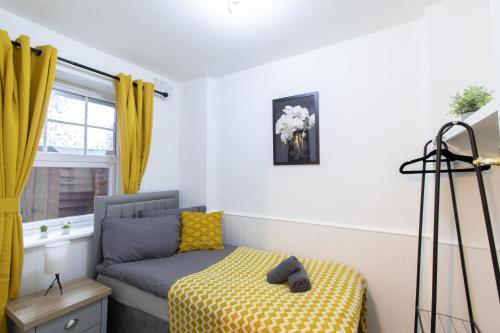 a room with a couch and a window with yellow curtains at Open Mind Property - Cosy Apartment with 3 Beds in Portsmouth