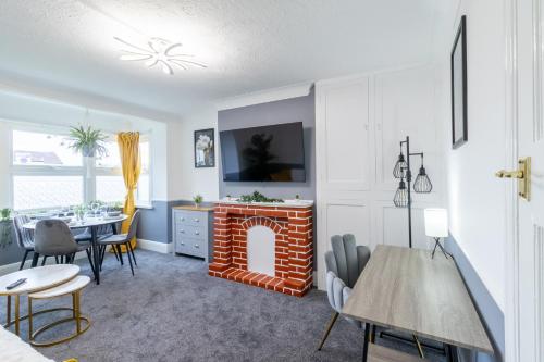 a living room with a fireplace and a table and chairs at Open Mind Property - Cosy Apartment with 3 Beds in Portsmouth